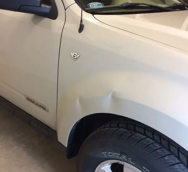 Small dent on a vehicle panel being assessed